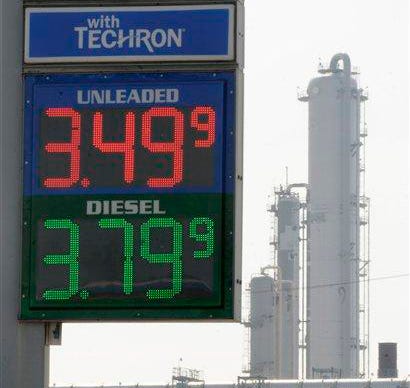 In this March 30, 2011 file photo, a Houston gas station displays its prices with a refinery stack in the background. Quick: What do these things have in common? Libyan leader Moammar Gadhafi. The Japanese earthquake and tsunami. Wall Street volatility. A cranky, even angry American populace. Answer: They all have something to do with gasoline. No matter what happens in the world today, just about everything seems to point back to fuel and the tricky politics that emerge when prices spike.