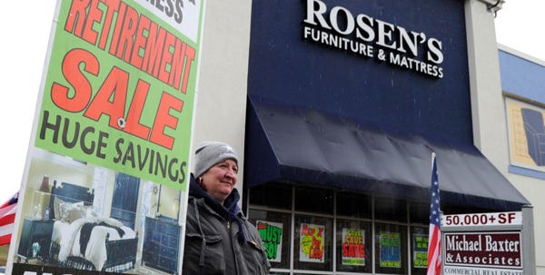 Undeterred by snow and rain, Kerri Aiello stands outside Rosen's Furniture in East Stroudsburg on Friday holding a sign touting the store's 'retirement sale.' The store will close by late summer, owner Carmen Valleri says.