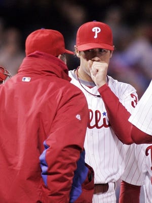 Philadelphia Phillies pitching coach Rich Dubee, left, talks with pitcher Cole Hamels during the third inning of a baseball game with the New York Mets Tuesday, April 5, 2011, in Philadelphia. Hamles left after giving up six runs in the inning. (AP Photo/Tom Mihalek)
