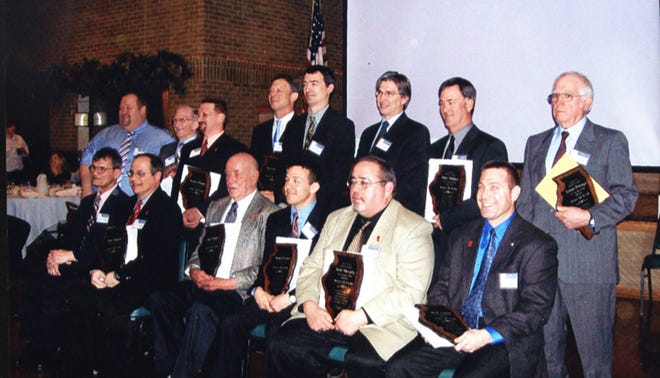 Lou Pronga, standing at far right, stands after being inducted into the Illinois Wrestling Coaches and Officials Hall of Fame Saturday.