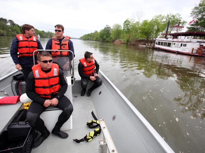 Tuscaloosa Fire and Rescue Service water rescue team members Tony Lester, left, Max Brom, Jason Whatley and Rhett Gallego, right, survey the shoreline of the Black Warrior River where triathletes will be swimming. The water rescue team has made multiple dives around the docks where swimmers will be entering the water to check for unseen obstructions underwater. Tuscaloosa will host the USA Triathlon Collegiate National Championships on Saturday.