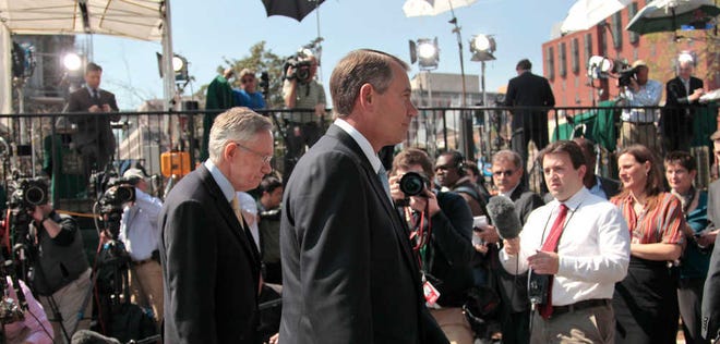 House Speaker John Boehner, right, and Senate Majority Leader Harry Reid walk past reporters outside the White House on Thursday in Washington after their meeting with President Barack Obama regarding the budget and possible government shutdown.