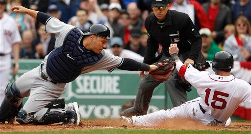 Boston Red Sox's Dustin Pedroia, right, beats the tag of New York Yankees catcher Russell Martin, left, to score safely on a single by Adrian Gonzalez in the second inning of a baseball game at Fenway Park in Boston, Friday, April 8, 2011. (AP Photo/Charles Krupa)