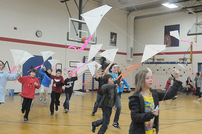 Fourth graders try out their new creations during a kite education workshop at Dighton Elementary School.