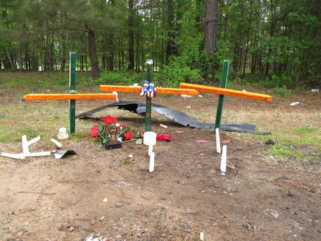 Three crosses stand as a memorial to high school senior Aaron Hill Friday, April 8, 2011 near the place on Highway 129 in Wellford , S.C., where he was killed in a car crash the day before on his way to school. The stretch of highway is named the Sergeant Shawn F. Hill Memorial Highway after Aaron Hill's father, who was killed in 2008 by a roadside bomb in Afghanistan. Now the highway represents a double tragedy for the family. (AP Photo/Jeffrey Collins)