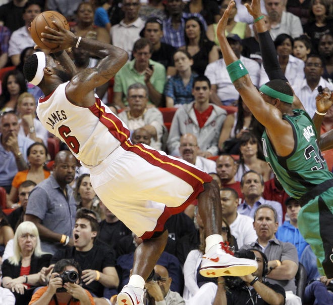Miami's LeBron James (left) fades away from Celtics forward Paul Pierce to shoot during yesterday's 100-77 Heat victory.