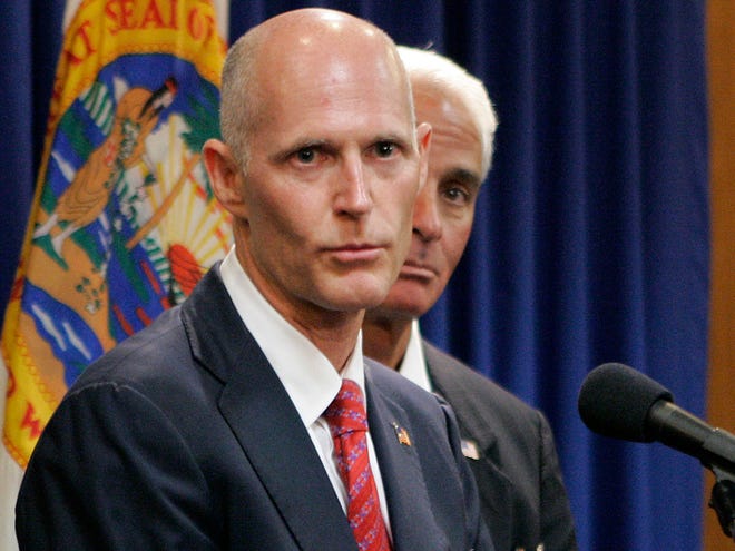 In this Nov. 9, 2010 file photo, Florida Gov.-elect Rick Scott, foreground, speaks at a news conference accompanied by then Gov. Charlie Crist listens in Tallahassee. (AP)