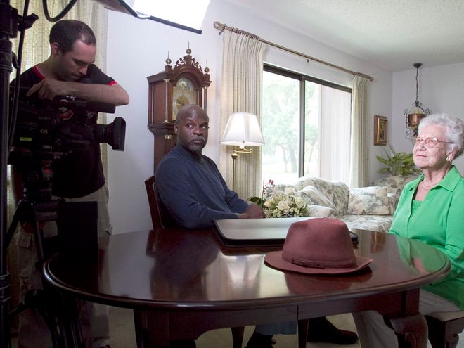 Ruth Sandholm, right, is interviewed by Tukufu Zuberi, center, as director of photography, Chuck Moss, both of the PBS show “History Detectives,” films at Sandholm's Silver Springs Shores home on Monday.