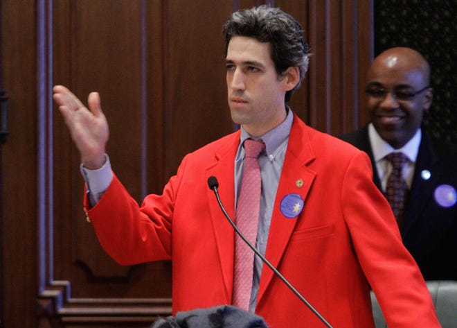 Illinois Rep. Daniel Biss, D-Evanston, wears a bright red jacket while arguing in support of his first bill on the House floor at the Illinois State Capitol. Seth Perlman/AP