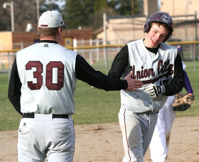 Union City’s Brady Johnson is congratulated by coach John Bain after clubbing a three-run homer on Monday. Johnson took the win on the mound in a 16-0 win in the opening game, and had three hits and six RBI on the day.