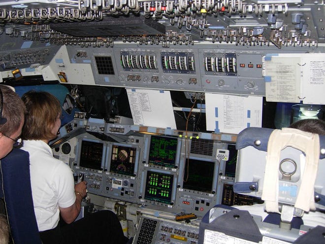 Susan King, co-founder and managing director for Wings of Dreams, tries her hand at flying the Space Shuttle Guidance and Navigation Simulator. (Photo courtesy of Wings of Dreams)