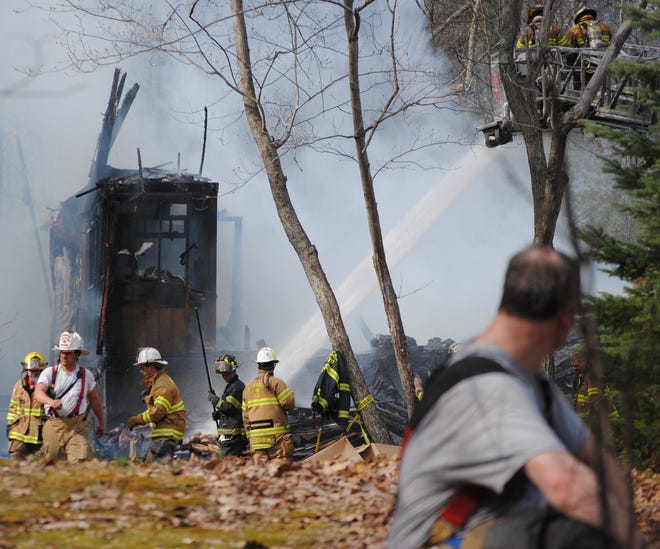 Firefighters work at the scene of a fire at 148 Pocono Circle West in Delaware Township on Monday.