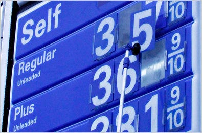 A worker changes the numbers to indicate new gasoline prices.