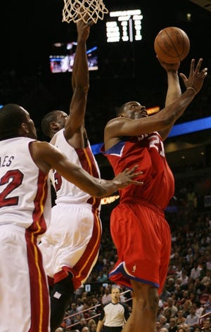 The Sixers' Thaddeus Young drives to the basket as the Heat's Dwyane Wade and James Jones (left) defend during the fourth quarter of Miami's March 25 win in South Florida. (AP Photo/Jeffrey M. Boan)