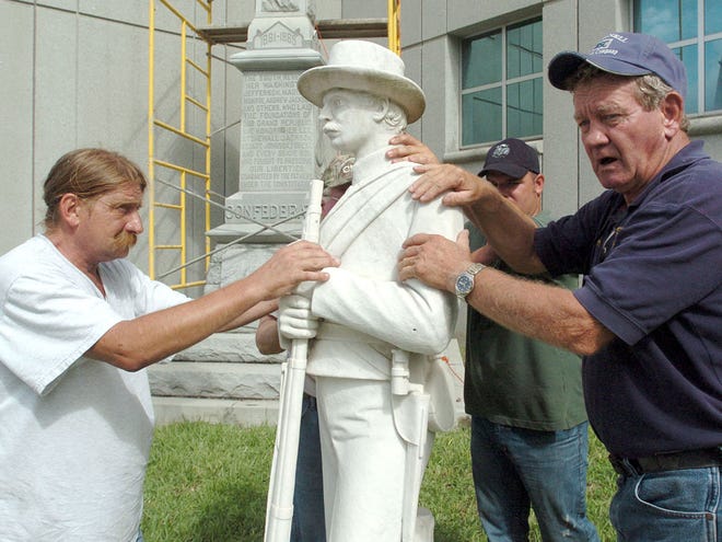 From left, David Bond, Travis LaPerle and Fred Smith guide the Johnny Reb statue to the ground outside the Marion County Courthouse on Aug. 23, 2010. It was reassembled at the Ocala-Marion County Veterans Memorial Park. The statue will be rededicated at a ceremony on Saturday.