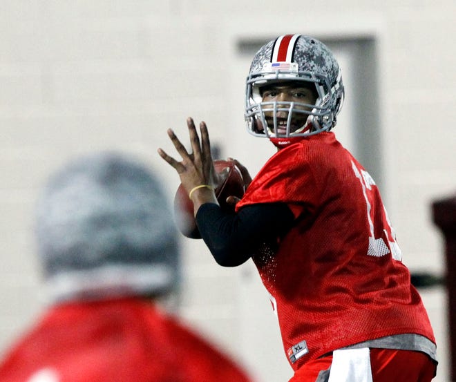 Ohio State quarterback Kenny Guiton (13) throws a pass to Daniel Herron (1) during the first day of spring practice in Columbus. With three-year starter Terrelle Pryor sidelined for the spring after surgery and also facing a five-game suspension this fall, the Buckeyes are looking at four candidates to take his spot until he plays in his first game in October. Joe Bauserman, Kenny Guiton, Taylor Graham and Braxton Miller are sharing the snaps during spring workouts.