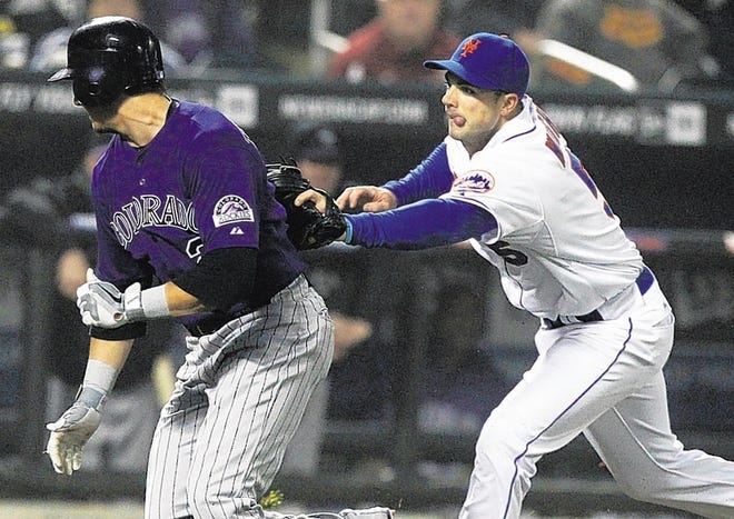 David Wright, right, runs down Rockies' Troy Tulowitzki in the second inning on Wednesday night.