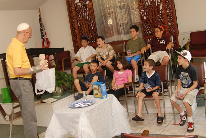 Rabbi Harold Caminker leads a lesson on Sunday for Temple Beth El's youth 
about the importance of a Seder dinner at the beginning of 
Passover.CORRESPONDENT PHOTO / LISA HLYWA
