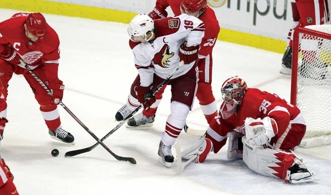 Detroit defenseman Nicklas Lidstrom (left) keeps the puck away from Phoenix right wing Shane Doan (19) in front of goalie Jimmy Howard during the third period in Game 2 Saturday in Detroit.