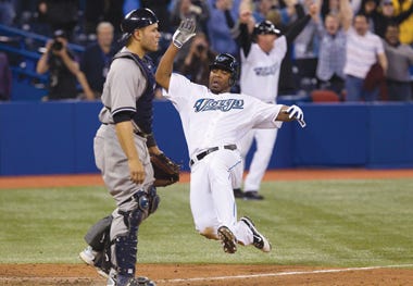Toronto Blue Jays' Edwin Encarncion slides into home base in front of New York Yankees catcher Russell Martin after teammate Travis Snider hit a double to deep center to beat the Yankees 6-5 in the tenth inning of a major league baseball game in Toronto on Tuesday, April 19, 2011. (AP Photo/The Canadian Press, Chris Young)