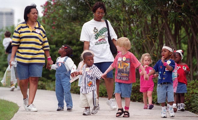 This stroll sponsored by the Jacksonville Childrens Commission in 2000 illustrates healthy behaviors. Taking a walk with parents for a picnic is one way to break out of the isolation so common in struggling neighborhoods.