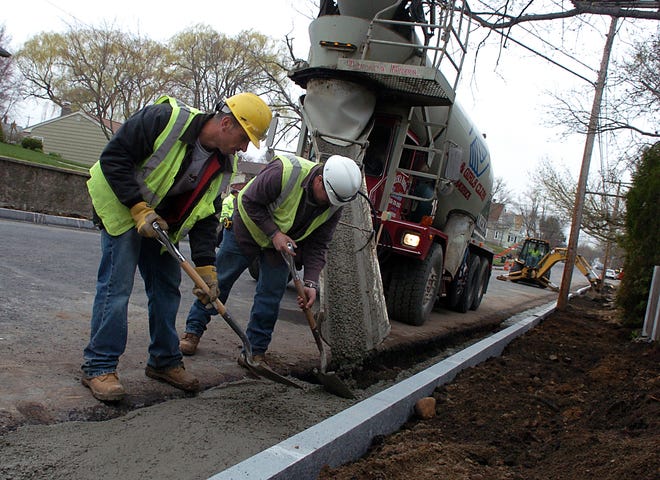 Paul Sa and Massers Amaral of FC Construction smooth out the concrete that holds the new Wachusett Street curbs in place Wednesday afternoon as the Wachusett Street construction continues.