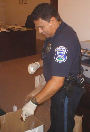 Saugatuck-Douglas Police Department Officer Tino Reyes sorts through unwanted prescription medication that was turned in last year as part of the first National Prescription Drug Take-Back Day.