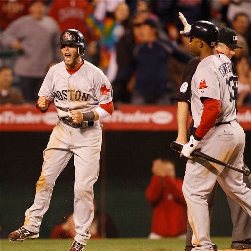 Boston Red Sox' Dustin Pedroia celebrates after scoring on a sacrifice fly by Jed Lowrie as Carl Crawford, right, watches during the eleventh inning of their baseball game against the Los Angeles Angels in Anaheim, Calif., Thursday, April 21, 2011. (AP Photo/Lori Shepler)