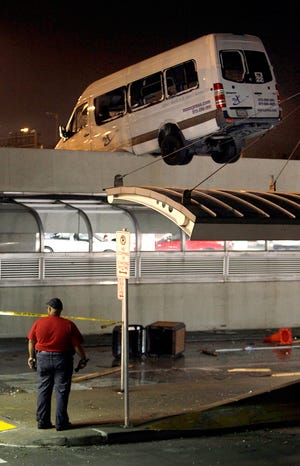 A MO-X van hangs over the side of a parking garage at Lambert-St. Louis International Airport Friday evening after a tornado hit the airport.