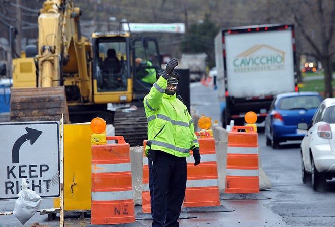 Framingham police officer Ron Cesar directs traffic at the Edgell Road and Auburn Street road construction site last week.