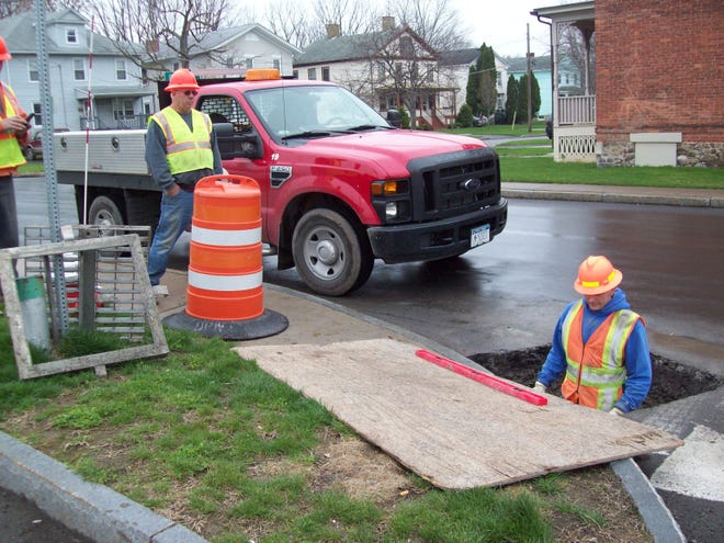 City crews dig up a catch basin on Beeman Street, and prepare the site for further repairs.