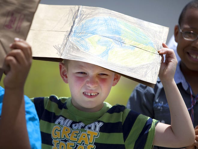 Mason Diehlman, 5, uses his Earth Day bag to shield his head from the sun at Marion Oaks Elementary School in Marion Oaks, Fla., on Monday, April 25, 2011. The program was part of a St. Johns River Water Management district program that promote water conservation in the schools. St. Johns teamed up with the school and Publix supermarket. The grocery store donated 800 shopping bags for the program. The bags, now that they are decorated, will go back to the store and be used for customer's groceries.
