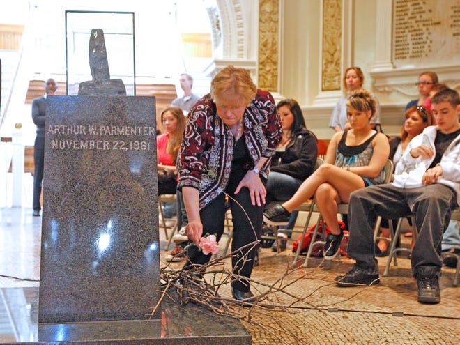 Mayor Linda Balzotti places a carnation during the Flowers for Victims event at City Hall on Tuesday.