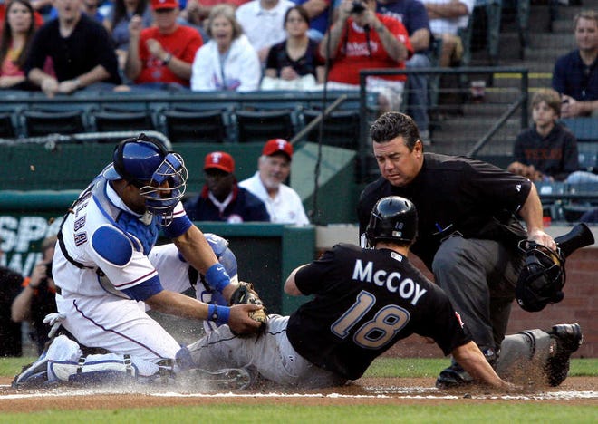 Texas Rangers catcher Yorvit Torrealba, left, tags out Toronto Blue Jays' Mike McCoy (18) as home plate umpire Rob Drake, right, looks on in the first inning of a baseball game onWednesday, April 27, 2011, in Arlington, Texas. McCoy was attempting to score on an Adam Lind single. (AP Photo/Tony Gutierrez)