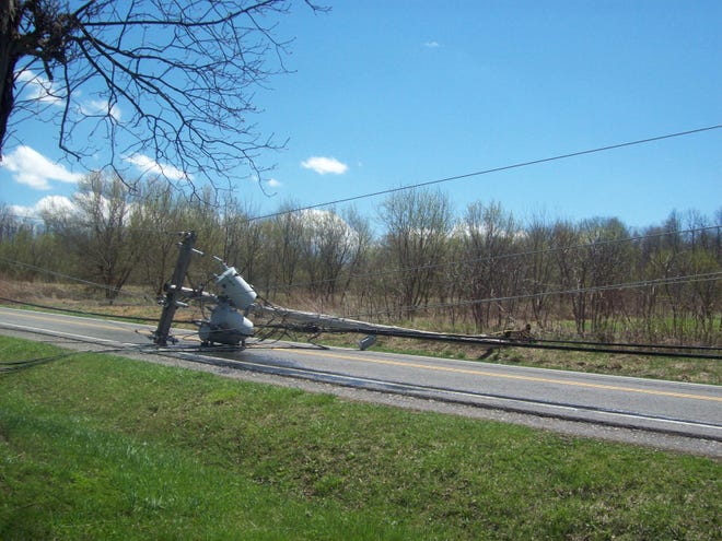 Soft ground and heavy winds yanked a utility pole out of the ground on Collett Road in Farmington, pulling down one power line and tipping two adjacent poles.