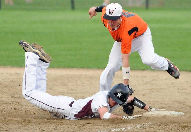 Weston's Zach Cannon slides back into first base under Wayland's EJ Nicholas' tag during yesterday's game.