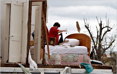 Glenda Dillshaw sorted through debris in Pleasant Grove, Ala., in Jefferson County.  The county is also dealing with a huge debt.