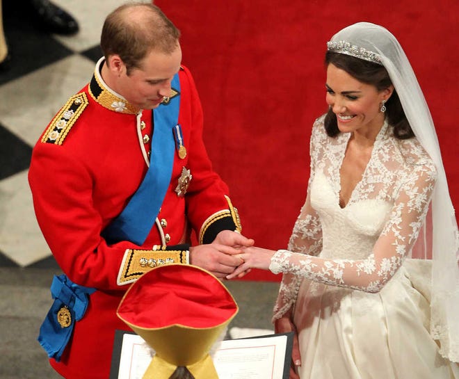 Kate looks as happy as a princess on her wedding day Friday as Prince William places the ring on her finger.