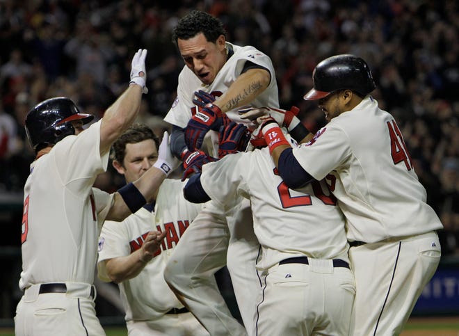 Cleveland Indians' Asdrubal Cabrera (top) and his teammates climb on Orlando Cabrera (second from right) after Cabrera's bases loaded single in the 13th inning drove in the winning run in a 3-2 win over the Detroit Tigers on Saturday in Cleveland.
