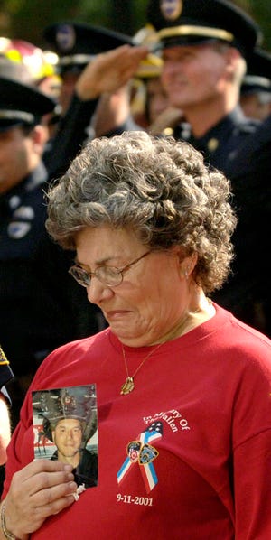 Marilyn Hess holds a photo of her son, Tommy Gambino Jr., a firefighter who died Sept. 11, 2001 at the World Trade Center. She was at Hemming Plaza during the Brother to Brother March Monday, September 11, 2006 in Jacksonville to commemorate the fallen firefighters and police that died in the 9/11 attack.