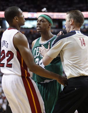 Boston Celtics' Paul Pierce, center, is held back by referee Ed Malloy after he was fouled by Miami Heat's James Jones (22) during the second half of Game 1 of a second-round NBA playoff basketball series, Sunday, May 1, 2011, in Miami. Pierce was ejected with 7 minutes left, after picking up two technicals in skirmishes with Dwyane Wade and Jones within a span of 59 seconds. The Heat defeated the Celtics 99-90. (AP Photo/Wilfredo Lee)