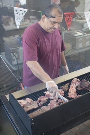 Bernie Perales grills beef for tacos at Arturo’s Tacos Friday during the Taste of Fiesta. The event continues today at Eighth Street Market Place and Holland Civic Center, 150 W. Eighth St.