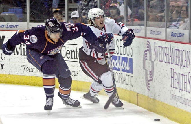 The IceHogs' Mathis Olimb (20) and Oklahoma City's Alex Plante (34) fight for the puck in the first period Friday, Jan. 21, 2011, during their game at the MetroCentre in Rockford.