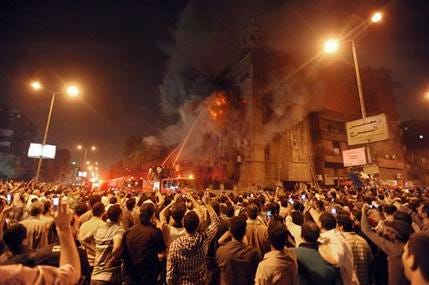 Firemen fight a fire at a church surrounded by angry Muslims in the Imbaba neighborhood in Cairo late Saturday, May 7, 2011. Christians and Muslims fought in the streets of western Cairo in violence triggered by word of a mixed romance, Egypt's official news agency reported.