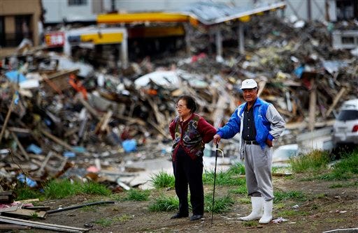 A couple stands and watches the aftermath of the March 11 earthquake and tsunami in Kesennuma, northeastern Japan, Tuesday, May 10, 2011.