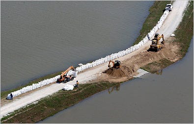 Workers fortified a levee on Monday near Morganza, La. Far upstream, the Mississippi River rose toward a crest in Memphis and was expected to soon reach 14 feet above flood stage. Officials warned residents in some parts of the city to evacuate.