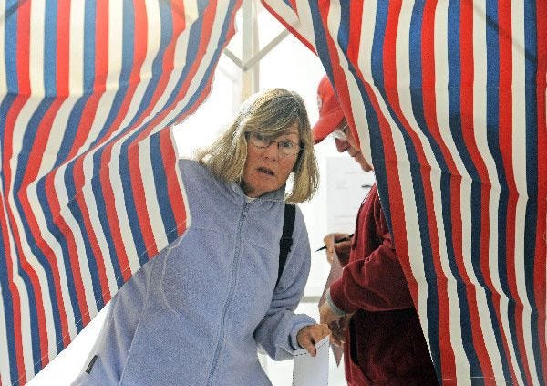 Precinct 4 voters Barbara and Richard Morency cast ballots Tuesday at the West Dennis Graded School. The Morencys, who have owned a house in Dennis for 10 years but only recently moved to the town full-time, said they voted to get involved in the community.