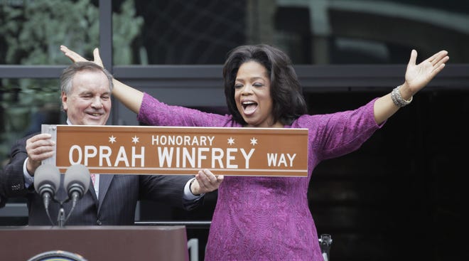 In one of his last acts before leaving office next week, Chicago Mayor Richard M. Daley presents TV talk-show host Oprah Winfrey with a sign after a street was named in her honor outside her Harpo Studios in Chicago, Wednesday, May 11, 2011. Winfrey will end her 25 year-run on daytime television in Chicago on May 25. (AP Photo/M. Spencer Green)