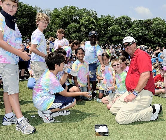 Golfer Chris Couch enjoys a moment with his son Christian during a special clinic for children Tuesday at TPC Sawgrass. Christian was there with his Timberlin Creek Elementary classmates and another 1,400 local students. By STAN BADZ, PGA Tour