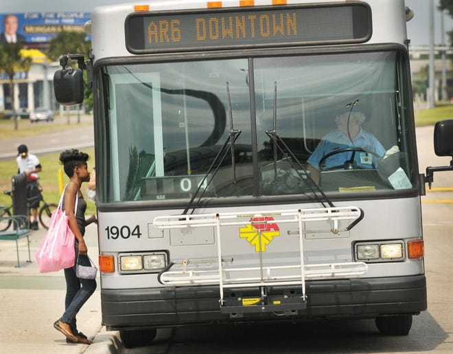 Merrill Road resident Dalaiah Simeon boards her bus Wednesday morning at the JTA bus stop in front of Regency Square in Jacksonville.